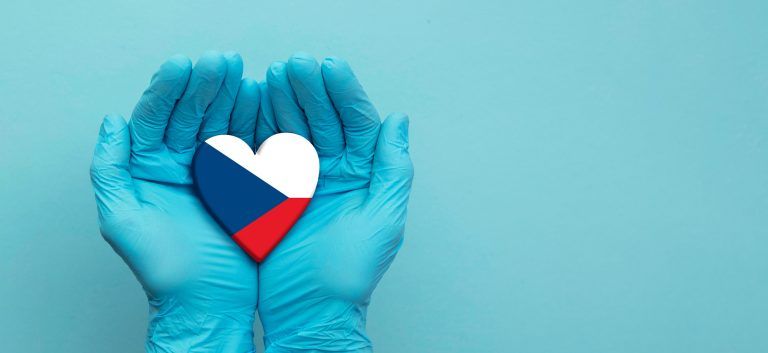 Plastic surgeon´s hands wearing surgical gloves holding czech republic flag heart