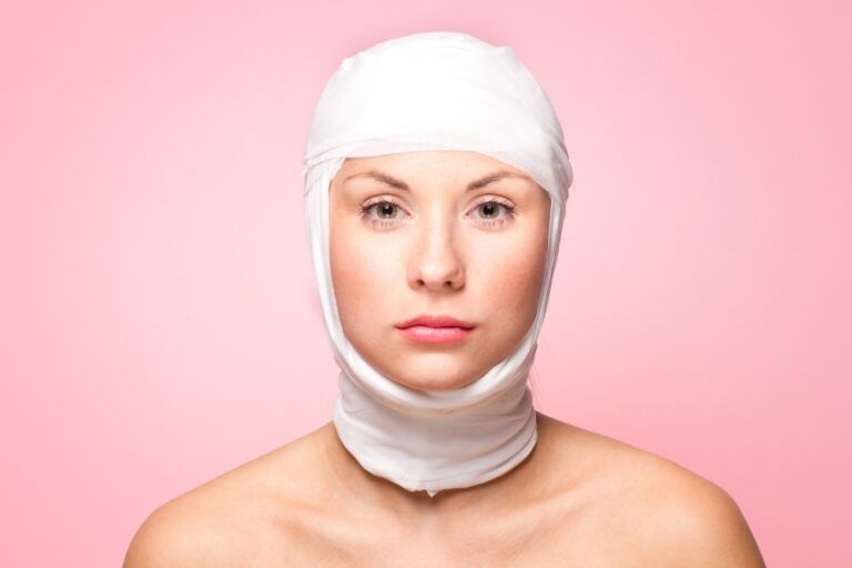 Woman with facial bandages after plastic surgery, illustrating post-operative recovery